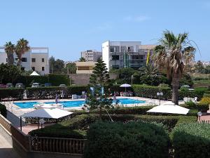 - une vue sur la piscine avec des parasols dans l'établissement Brezza Marina Apartment, à Trapani