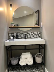 bagno con lavandino, specchio e asciugamani di Grayling Cottage ad Ambleside