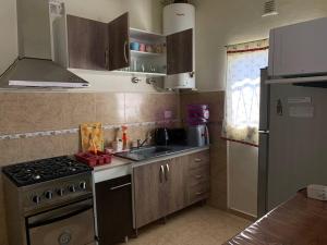 a kitchen with a stove and a sink and a refrigerator at Casa Hotel Cactus 15 minutos desde Ezeiza. in Monte Grande