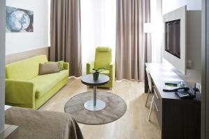 a living room with a yellow couch and a tv at Norlandia Tampere Hotel in Tampere