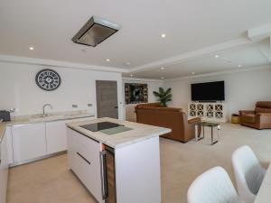 a kitchen and living room with a couch and a tv at 13 Cliff Edge in Newquay