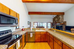 a large kitchen with wooden cabinets and a fireplace at Tahoe Enchantment in Zephyr Cove