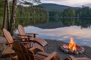 a fire pit on the shore of a lake at The Queen's Hut in Aboyne