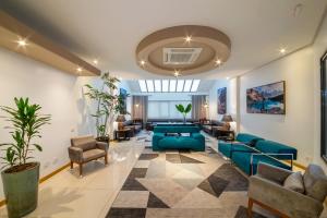 sala de estar con sofá azul y sillas en Hotel Laghetto Viale en Gramado