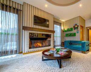 a living room with a fireplace and a blue couch at Hotel Laghetto Viale in Gramado