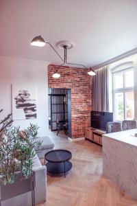 uma sala de estar com um sofá e uma lareira de tijolos em Apartments Kwidzyn em Kwidzyn