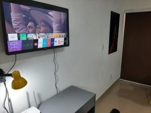 a flat screen tv hanging on a wall at Ribeirania-Zeus 67-Garagem-WIFI-Pet Friendly in Ribeirão Preto