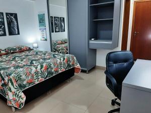 a bedroom with a bed and a desk and a chair at Ribeirania-Zeus 67-Garagem-WIFI-Pet Friendly in Ribeirão Preto