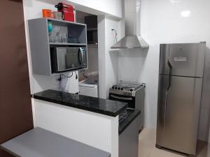 a small kitchen with a refrigerator and a microwave at Ribeirania-Zeus 67-Garagem-WIFI-Pet Friendly in Ribeirão Preto