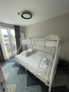 a bedroom with two bunk beds and a window at HOTEL LEHOUCK in Koksijde