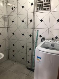 a bathroom with a toilet and a tile wall at Lindo Apartamento ! in Manaus