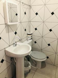 a bathroom with a sink and a toilet and a mirror at Lindo Apartamento ! in Manaus