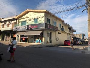 two people crossing a street in front of a building at Lindo Apartamento ! in Manaus