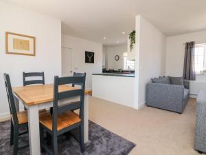 a kitchen and living room with a wooden table and chairs at 1 Marsh Gardens in Dunster