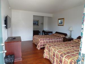 a hotel room with two beds and a flat screen tv at Travel Inn in North Hills