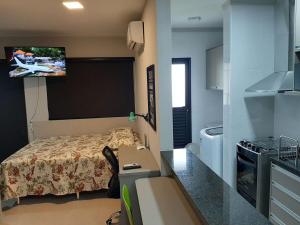 een kleine slaapkamer met een bed en een tv aan de muur bij Nova Aliança 66-wifi-estacionamento-pet friendly in Ribeirão Preto