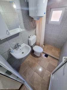 フォチャにあるAdventure Taraの白いトイレと洗面台のあるバスルーム