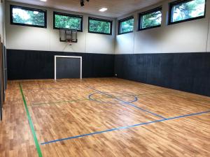 ミルシュタットにあるFamilienhotel Postの木製の床とバスケットボールコートが備わるジムを提供しています。