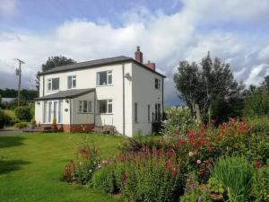 a white house with a garden in front of it at Country Home with Gardens in Newtown