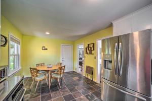 a kitchen with a table and a stainless steel refrigerator at Tulsa Family Home with Yard Less Than 6 Mi to Downtown! in Tulsa