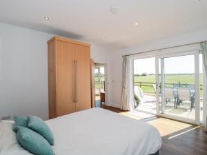 a bedroom with a bed and a sliding glass door at Robins Corner in Weston-super-Mare