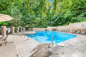 a swimming pool with chairs and an umbrella at Almost Heaven in Pigeon Forge
