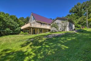a large house on a grassy hill with trees at Modern Eckerty Home with Deck on Patoka Lake! in Taswell
