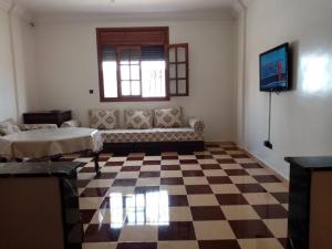 Grand Appartement à 5 mn de la plage في أغادير: غرفة معيشة مع أريكة وأرضية مصدية