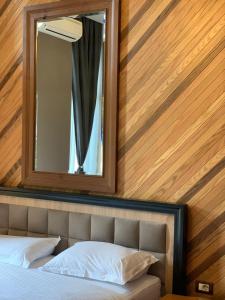 a mirror above a bed in a room at Guest House People in Korçë