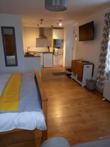 a bedroom with a bed and a kitchen at The Little Barn in Carlby