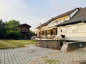 un edificio con una pasarela de piedra junto a una casa en Heviz Apart Comfort, en Hévíz