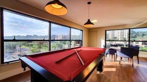 a red pool table in a room with windows at Infinite-WIFI-Garagem-Self check-in-Pet friendly in Ribeirão Preto