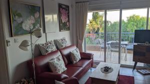 sala de estar con sofá, TV y balcón en P.Gardens 103, en Peyia
