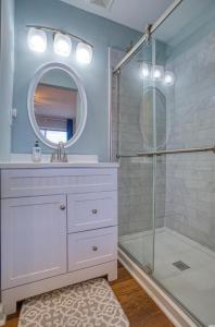 a bathroom with a shower and a sink and a mirror at BEAUTIFUL BEACHFRONT-Oceanfront First Floor 2BR 2BA Condo in Cherry Grove, North Myrtle Beach! RENOVATED with a Fully Equipped Kitchen, 3 Separate Beds, Pool, Private Patio & Steps to the Sand! in Myrtle Beach
