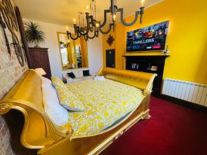 um sofá dourado numa sala de estar com uma televisão em PHOENIX Apartments em Goole