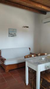 une chambre avec un banc blanc et une table dans l'établissement Casa Simetite, à Granelli