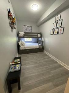 a bedroom with two bunk beds and a table at Modern Townhouse with Pool Close to Disney & Silver Spurs Arena in Kissimmee