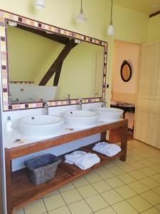 a bathroom with three sinks and a large mirror at Clos de la ruche in Cour-sur-Loire