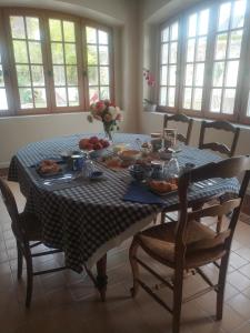 uma mesa de jantar com uma toalha de mesa azul e branca xadrez em Clos de la ruche em Cour-sur-Loire