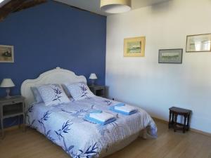 um quarto com uma cama branca e paredes azuis em Clos de la ruche em Cour-sur-Loire