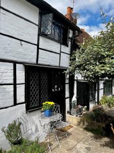 une table et des chaises devant une maison dans l'établissement 15th century tiny character cottage-Henley centre, à Henley-on-Thames