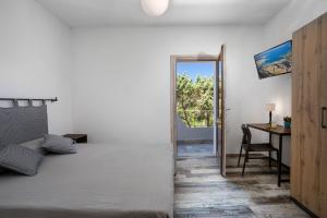 a bedroom with a bed and a table and a desk at Il Mirto in Baja Sardinia