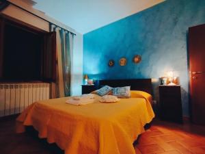 コルトーナにあるLa Casa Tra Gli Uliviの青いベッドルーム(タオル付きのベッド付)