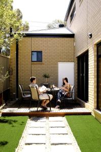 two people sitting at a table on a patio at Abode Bendigo Apartments in Bendigo