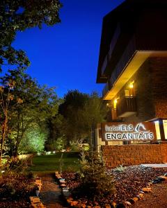 una señal de hotel frente a un edificio por la noche en Hotel Els Encantats, en Espot