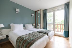 a bedroom with a large bed and a large window at Club Wyndham Normandy in Connelles