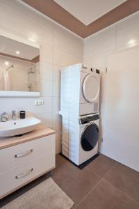 ein Badezimmer mit einer Waschmaschine und einem Waschbecken in der Unterkunft Deluxe - Nationalpark - groß, erholsam, familienfreundlich, extras in Ellweiler