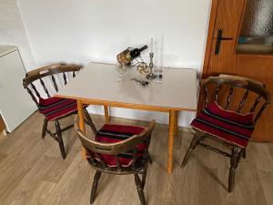 a table with two chairs and a bottle of wine at Apartmani Laušević in Žabljak