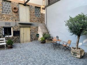 a courtyard with chairs and a tree and a building at Spatzennest am Taubenhaus Residenz Moselliebe in Traben-Trarbach
