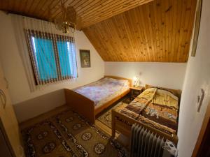 an attic bedroom with two beds and a window at Apartmani Laušević in Žabljak